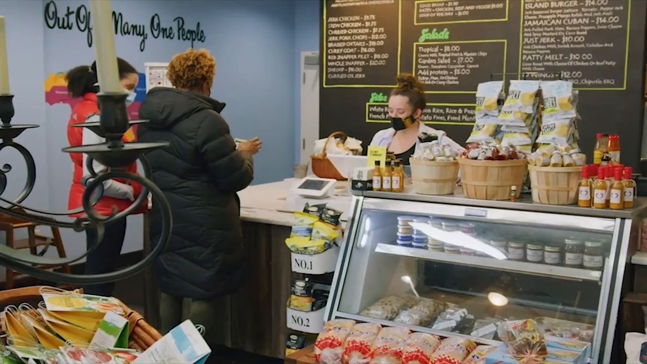 Guests ordering at the counter of Minston’s Jamaican Deli